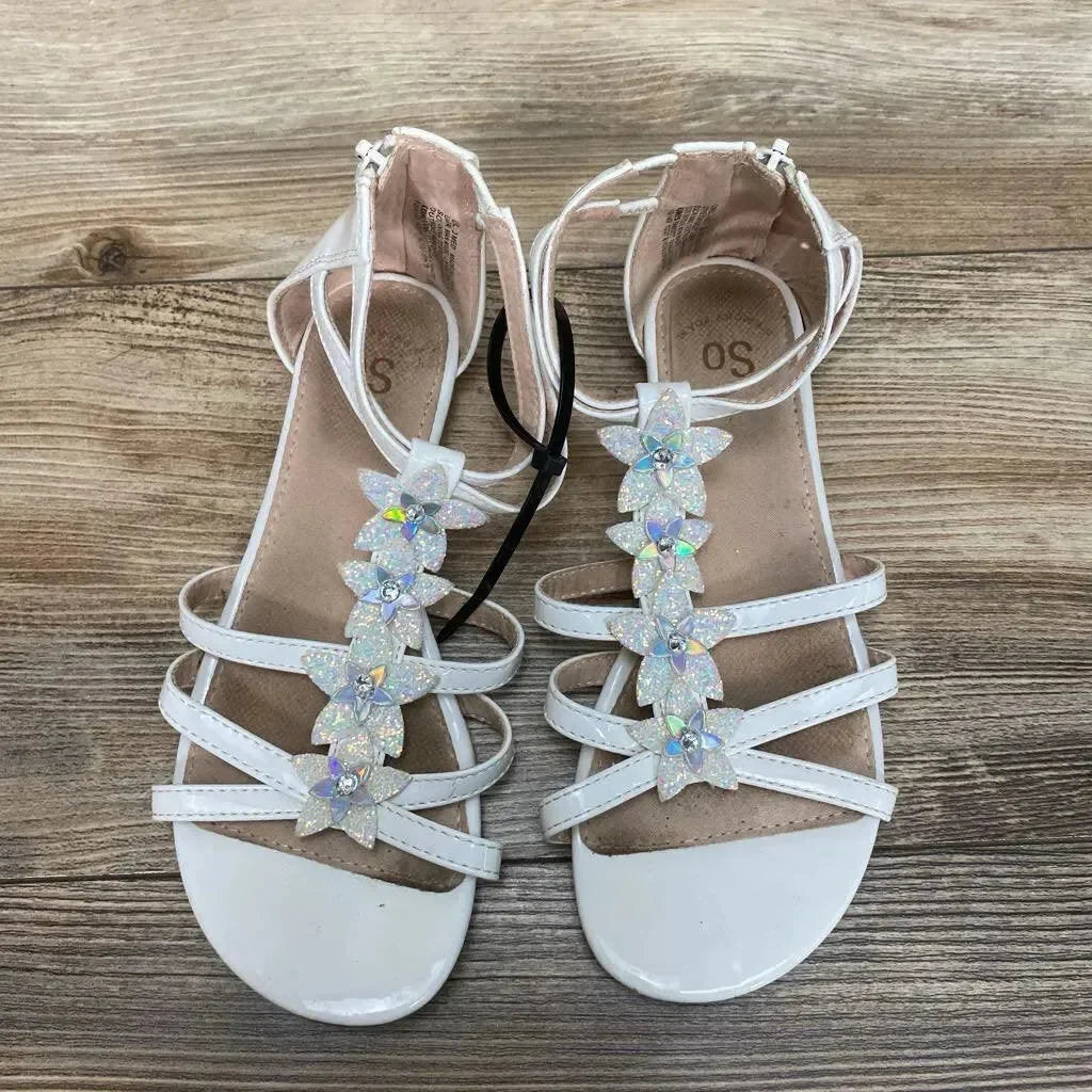 Top view of white New SO Tangelo girls' sandals size 3Y showcasing holographic flower embellishments on T-strap with wood-grain background