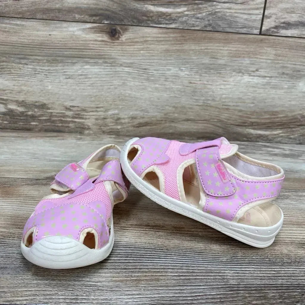 Three-quarter view of pink toddler sandals with closed-toe, star-print microfiber upper and Velcro strap on wood background