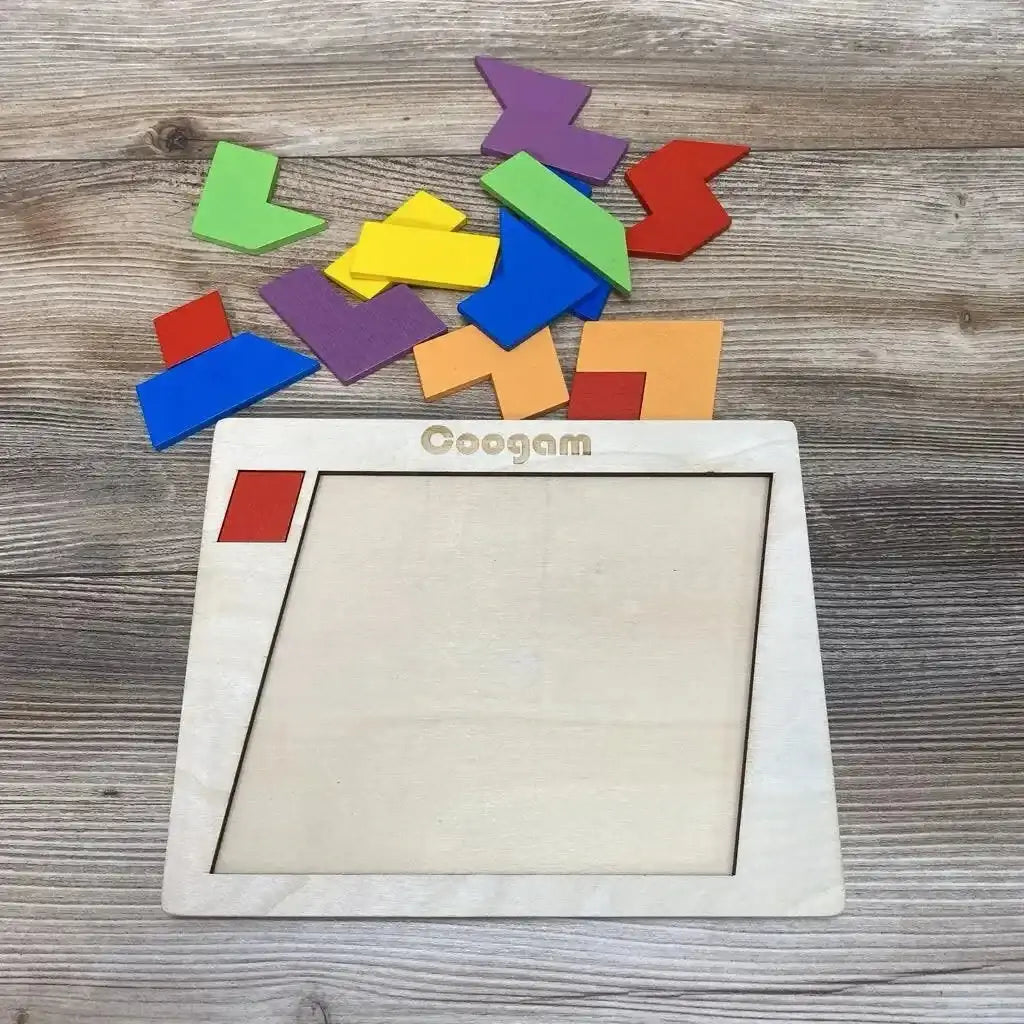 Overhead view of Coogam wooden puzzle frame with colorful geometric pieces scattered on a wood-grain tabletop