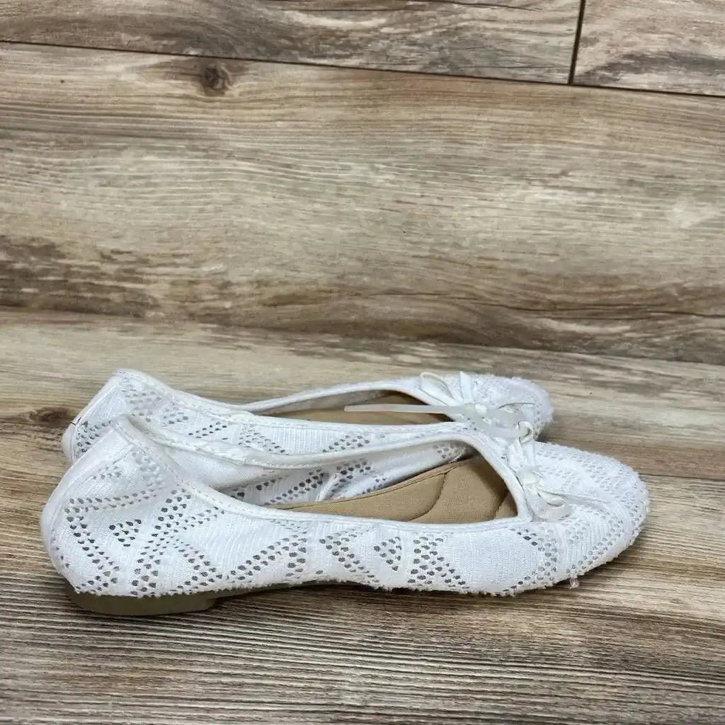 Side view of white SO Pensacola bow ballet flats size 6Y showing lace knit upper and decorative bow on wooden floor background