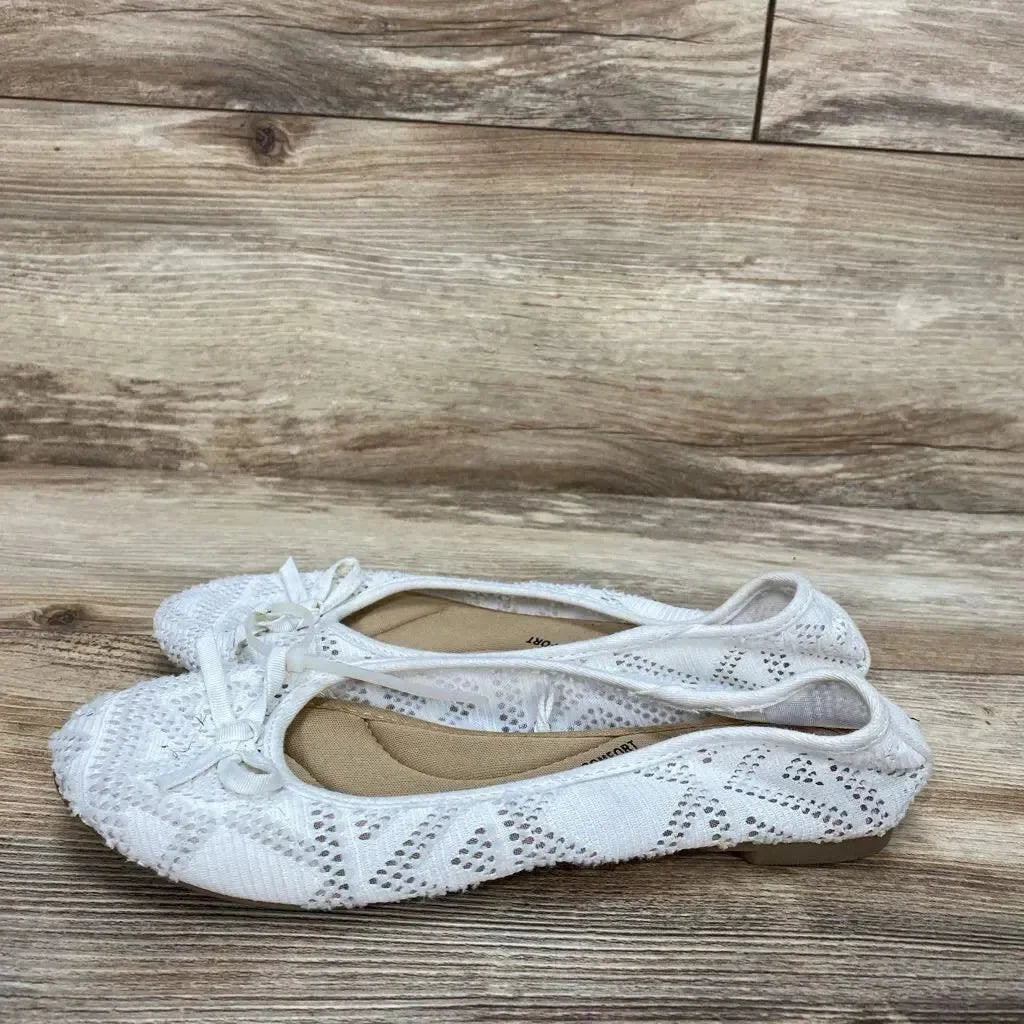 Side view of white SO Pensacola bow ballet flats (size 6Y) showcasing lace-knit upper and small front bow on wood-look floor