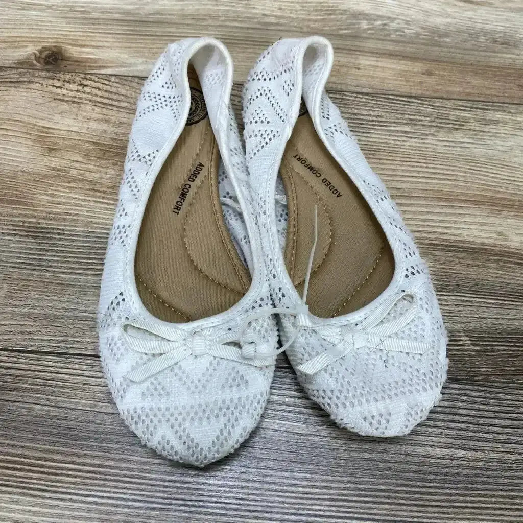 Overhead view of SO Pensacola white knit bow ballet flats, size 6Y, showing crocheted pattern and front bows on a wood floor