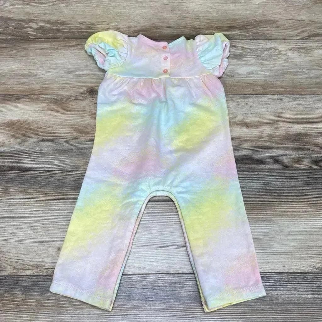 Flat lay of First Impressions baby romper in pastel tie-dye with puff sleeves and three-button front, on wood background
