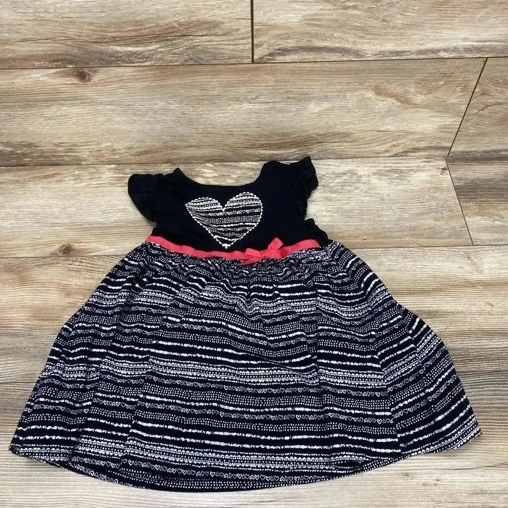 Flat lay of toddler navy dress (4T) with white patterned heart on bodice, striped skirt and pink sash on wood floor