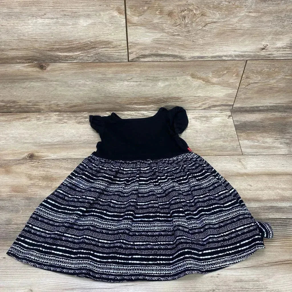 Flat lay of black Epic Threads toddler dress size 4T showing short puff sleeves and striped heart-patterned skirt on light wood background