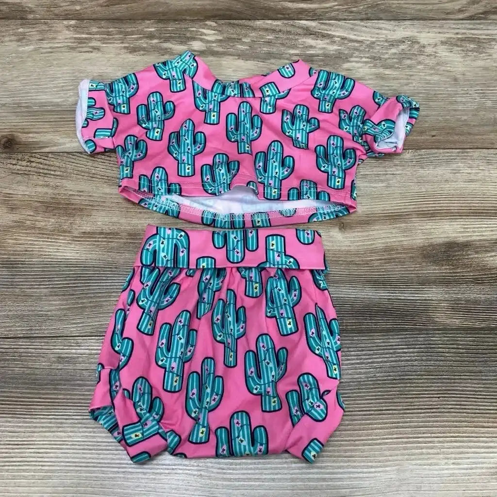 Flat lay of two-piece baby outfit size 3 months showcasing pink cactus-print shirt and matching bloomers on wood background