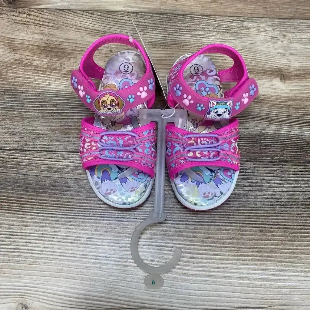 Top view of NEW Paw Patrol Adventure ankle strap sandals size 9c showcasing pink straps with Skye and Everest character print on wood plank floor