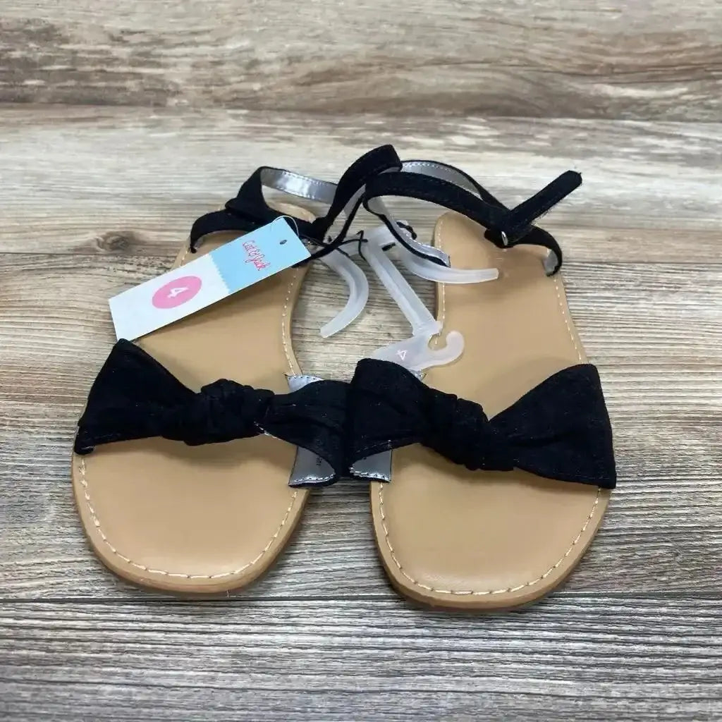 Top-down view of Cat & Jack Lydia sandals in black, size 4Y, showing knotted bow front and ankle strap on wood background