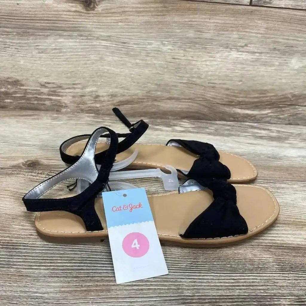 Side view of Cat and Jack Lydia toddler sandals in black with knotted front, ankle strap, and size 4 tag on wood floor
