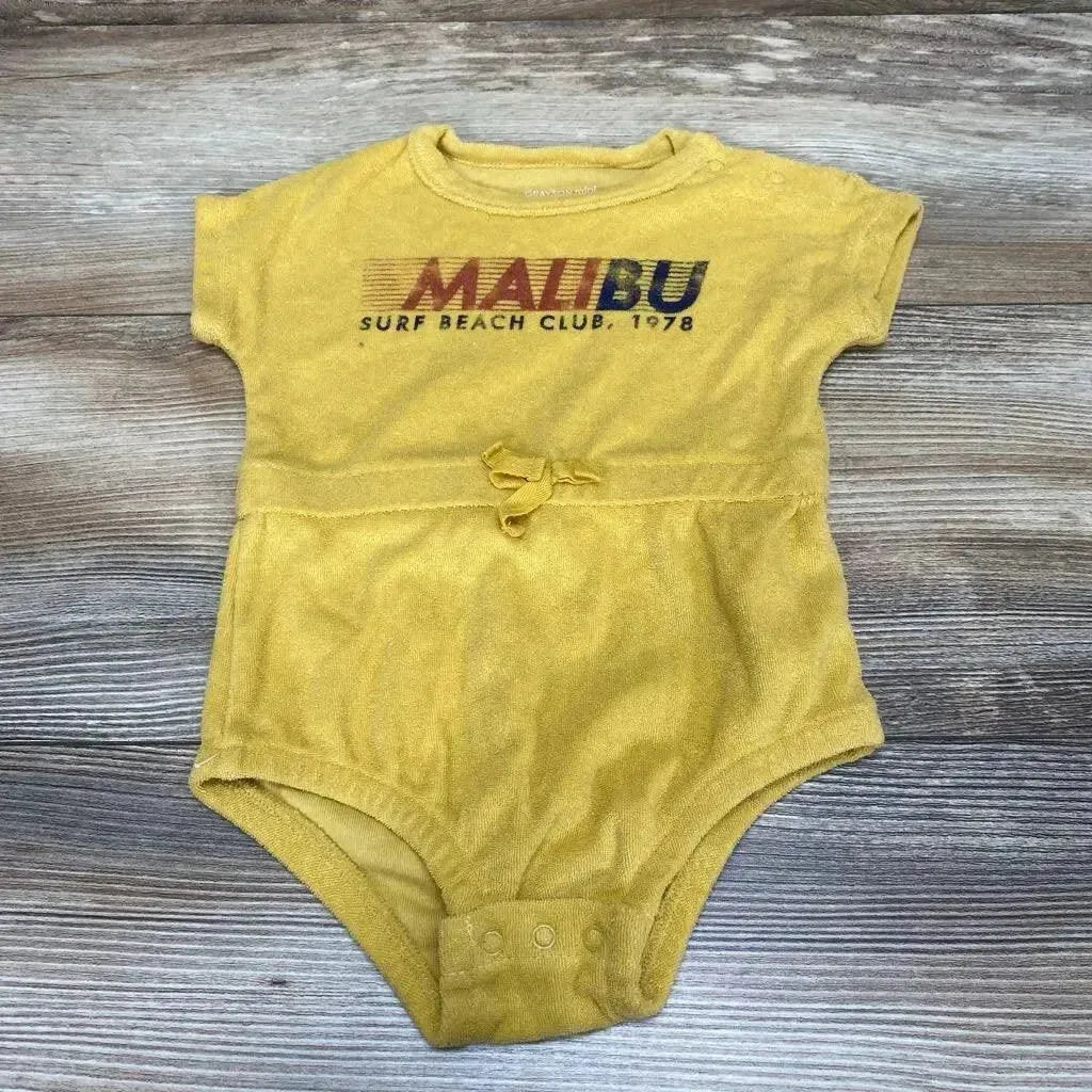 Flat-lay yellow terry baby romper size 3-6m showing MALIBU Surf Beach Club 1978 print, waist tie and snap crotch on wood