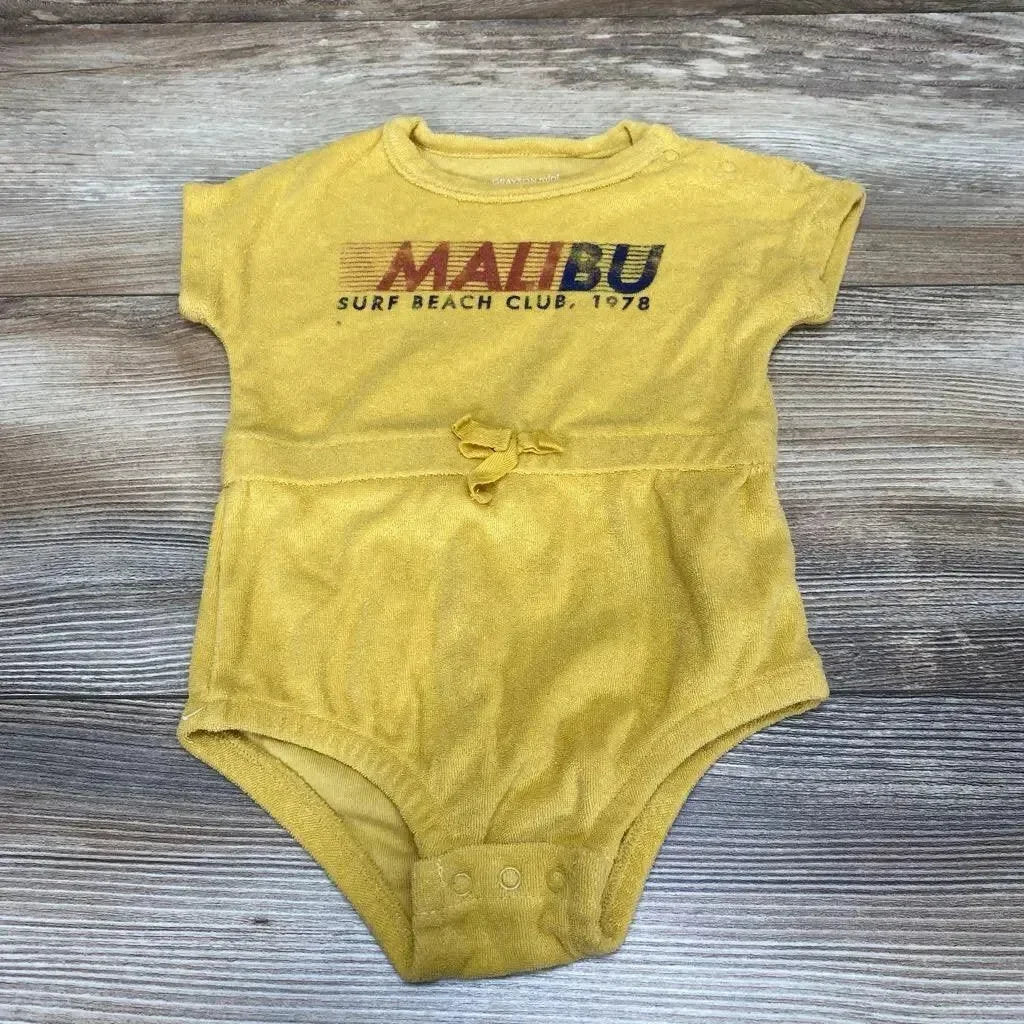 Flat-lay yellow terry baby romper size 3-6m showing MALIBU Surf Beach Club 1978 print, waist tie and snap crotch on wood