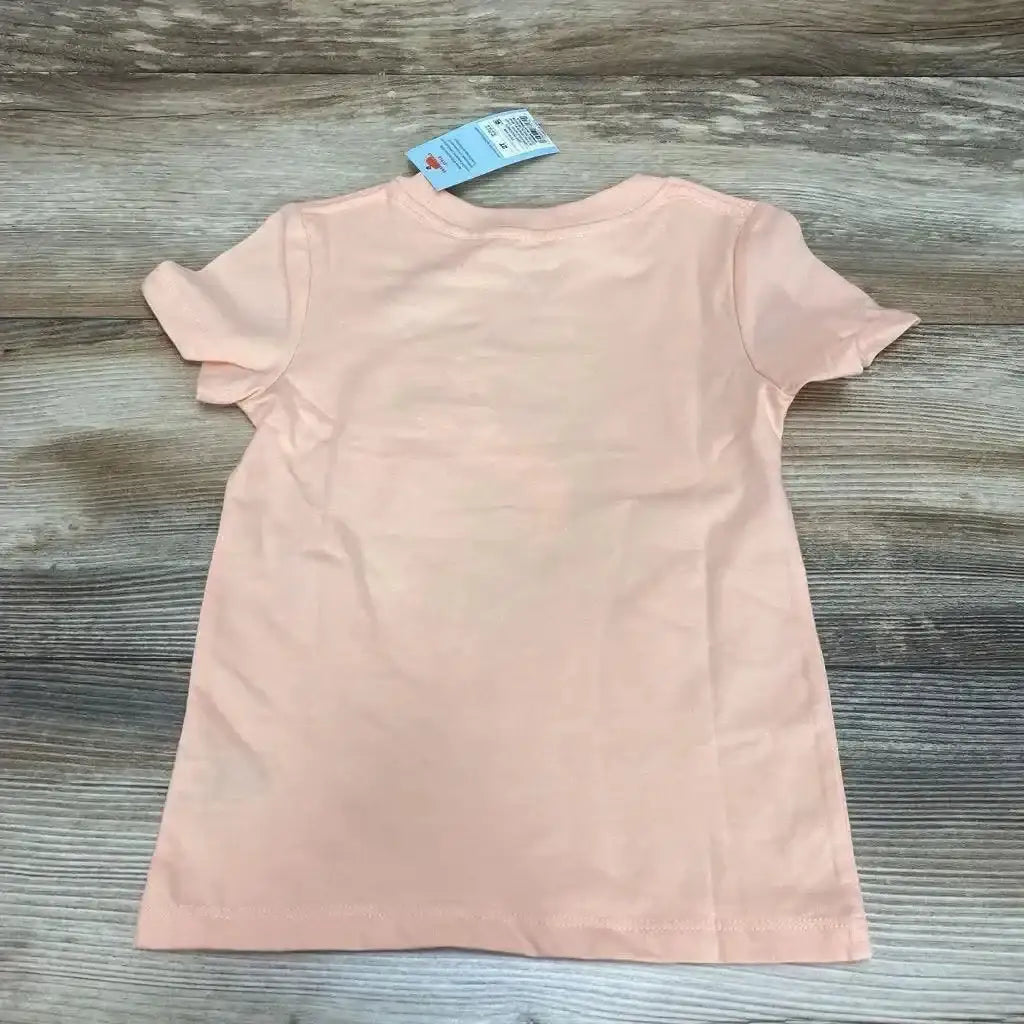 Back view of Cat & Jack peach toddler 2T t-shirt showcasing short sleeves and attached tag on wood plank background
