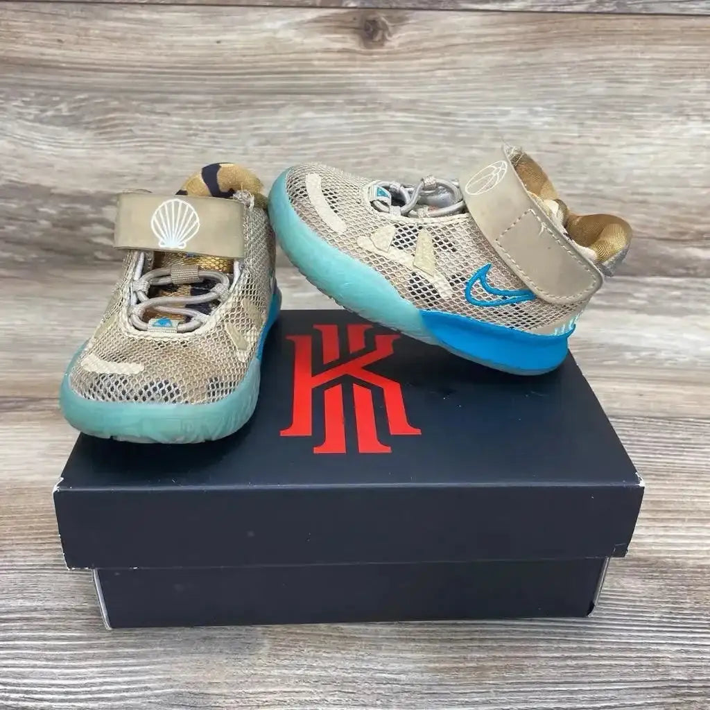 Front view of toddler Nike Kyrie 7 Ripple sneakers showcasing tan mesh upper, teal ripple sole, and velcro strap with shell logo on a black Kyrie shoebox