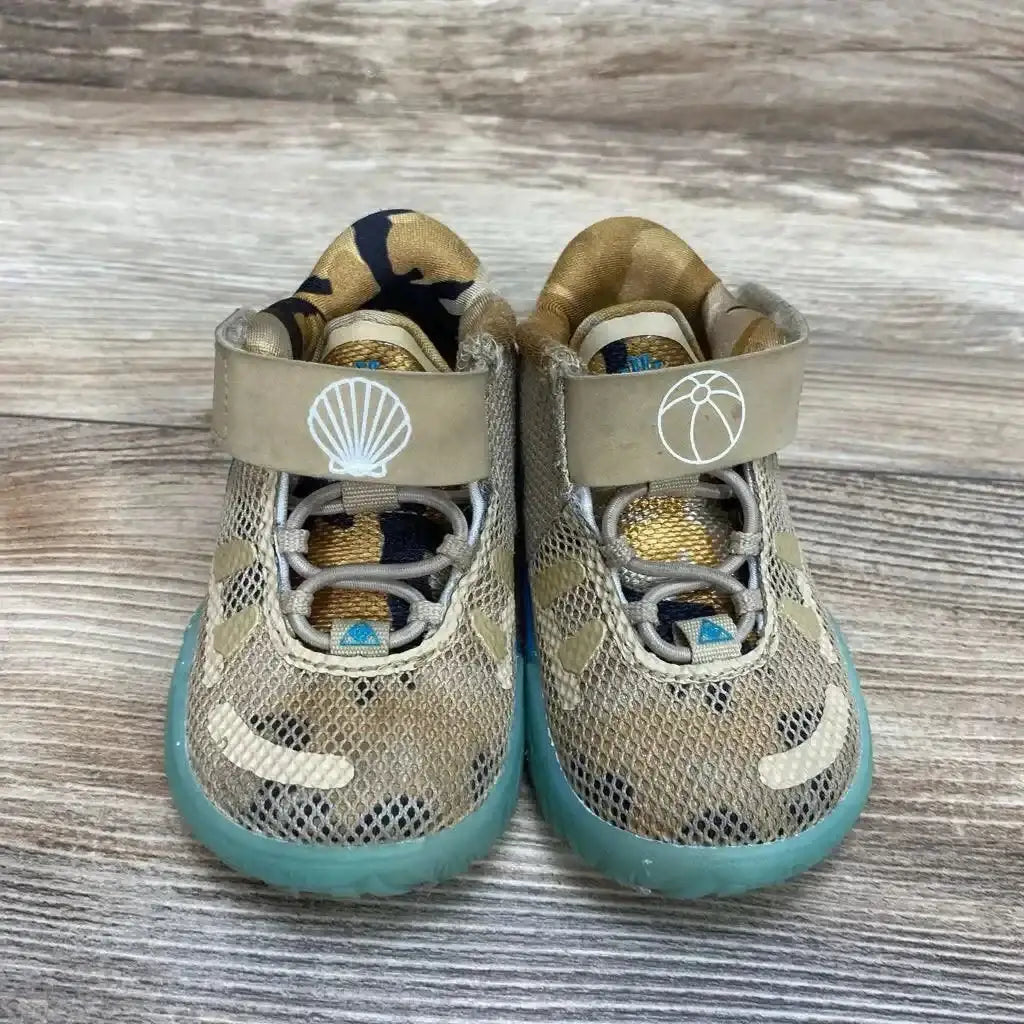 Front view of Nike Kyrie 7 Ripple sneakers in tan with seashell and beach ball graphics and aqua sole on wood plank floor
