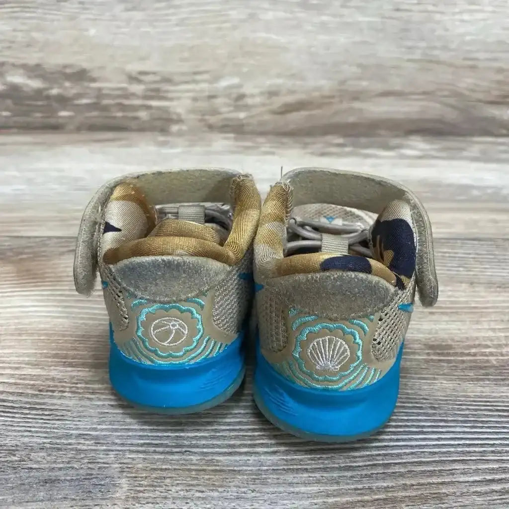 Rear view of Nike Kyrie 7 Ripple toddler sneakers with blue soles, shell and basketball embroidery, Velcro straps on wood floor