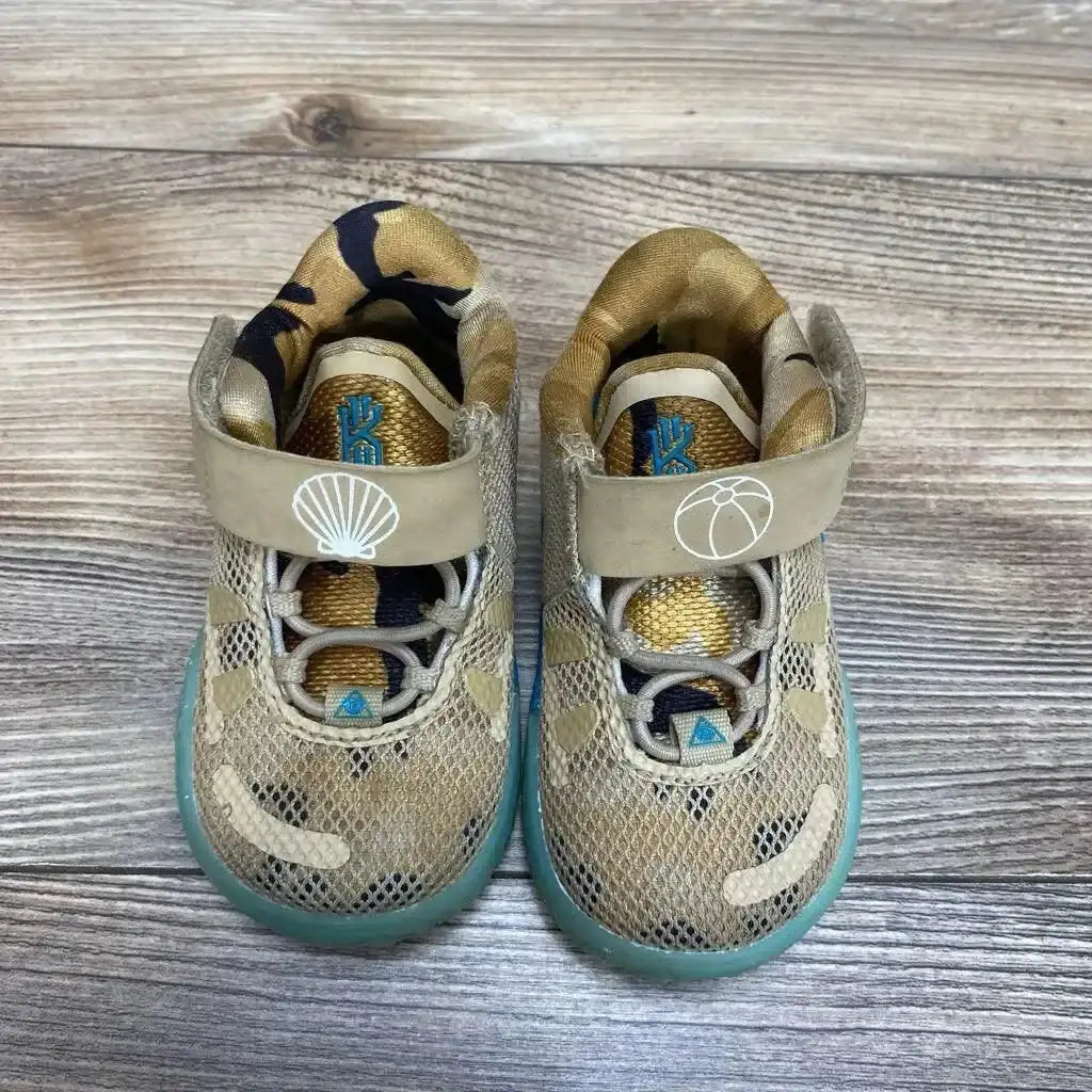Top view of tan Nike Kyrie 7 toddler sneakers size 4C showing mesh upper, Velcro strap icons, and teal sole on wood floor