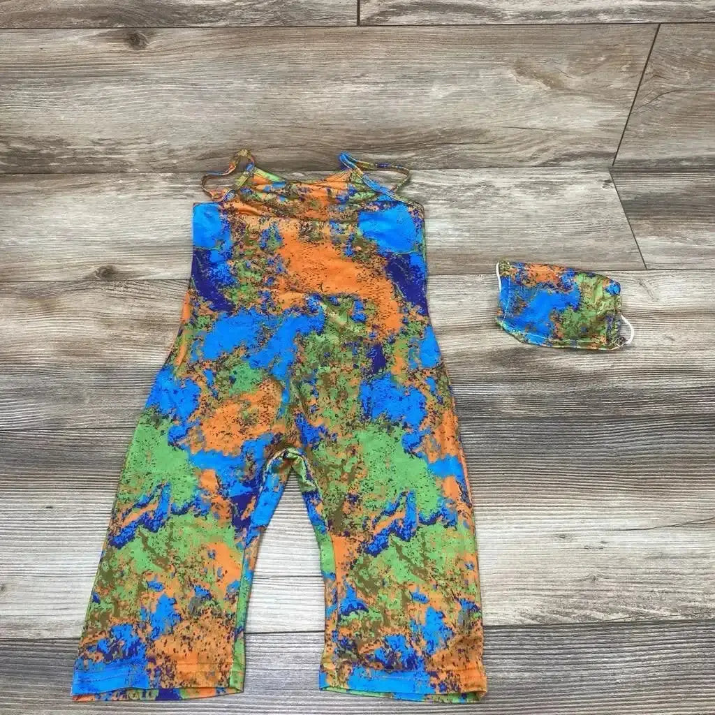 Flat lay of two piece cami romper and matching mask in blue orange and green tie dye splatter print on wood plank floor