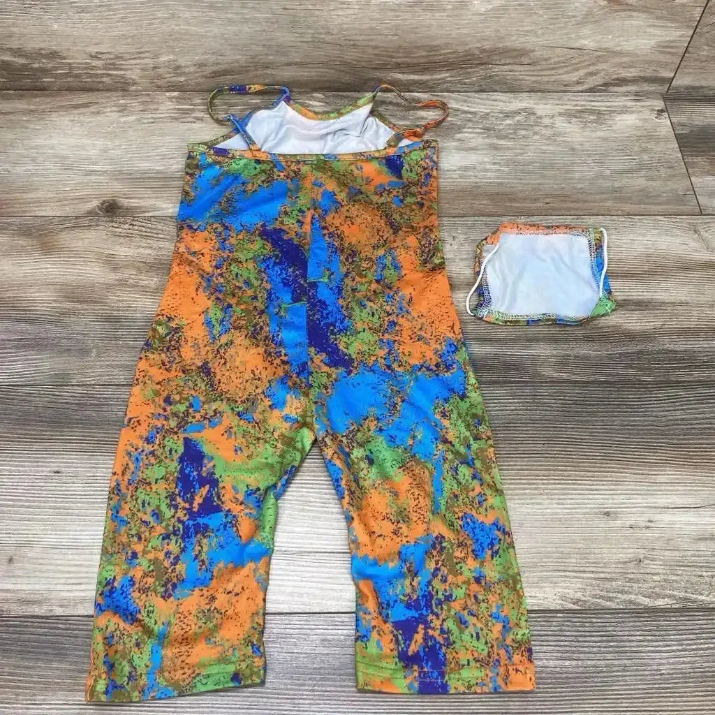 Flat lay of 4T cami romper and matching face mask showcasing abstract orange, blue, and green print on wooden floor