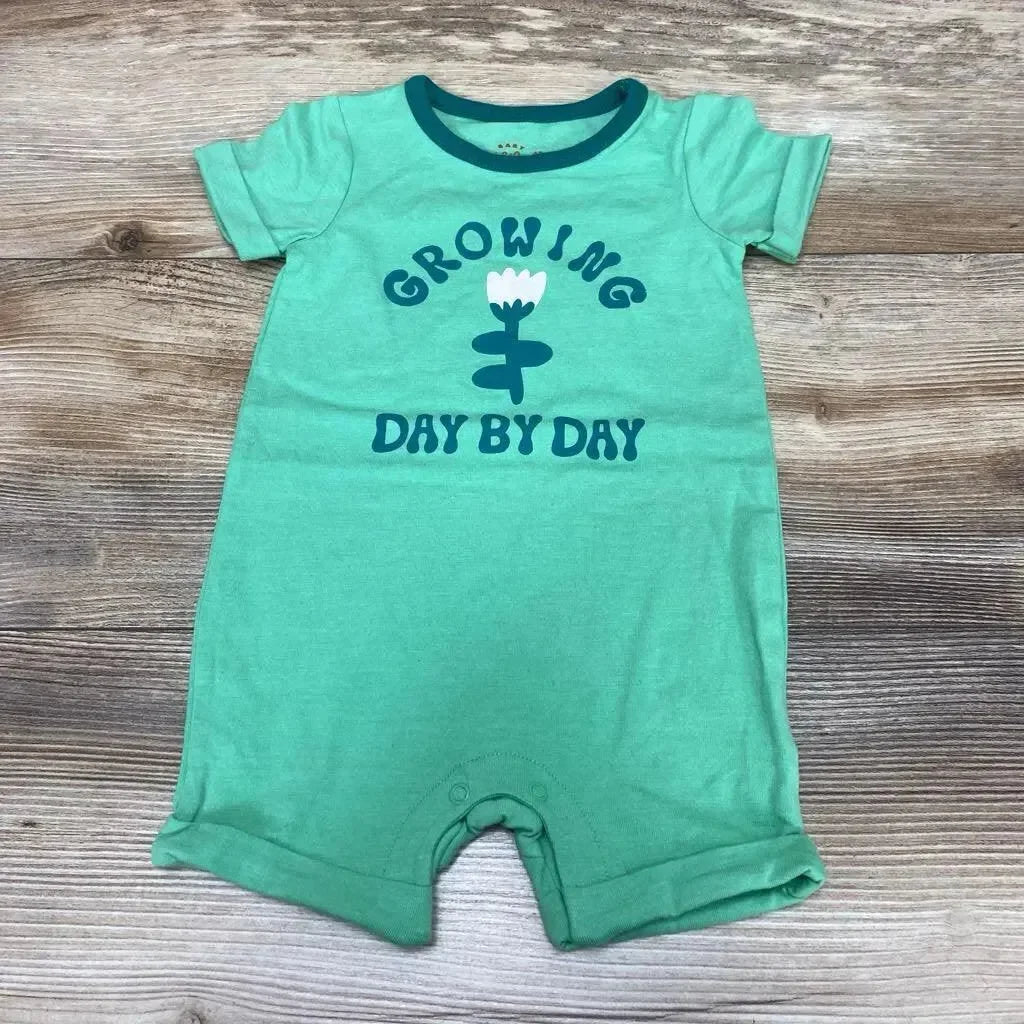 Front flat-lay of green Cat & Jack shortie romper (3-6m) showing Growing Day by Day flower graphic, snap crotch on wood floor