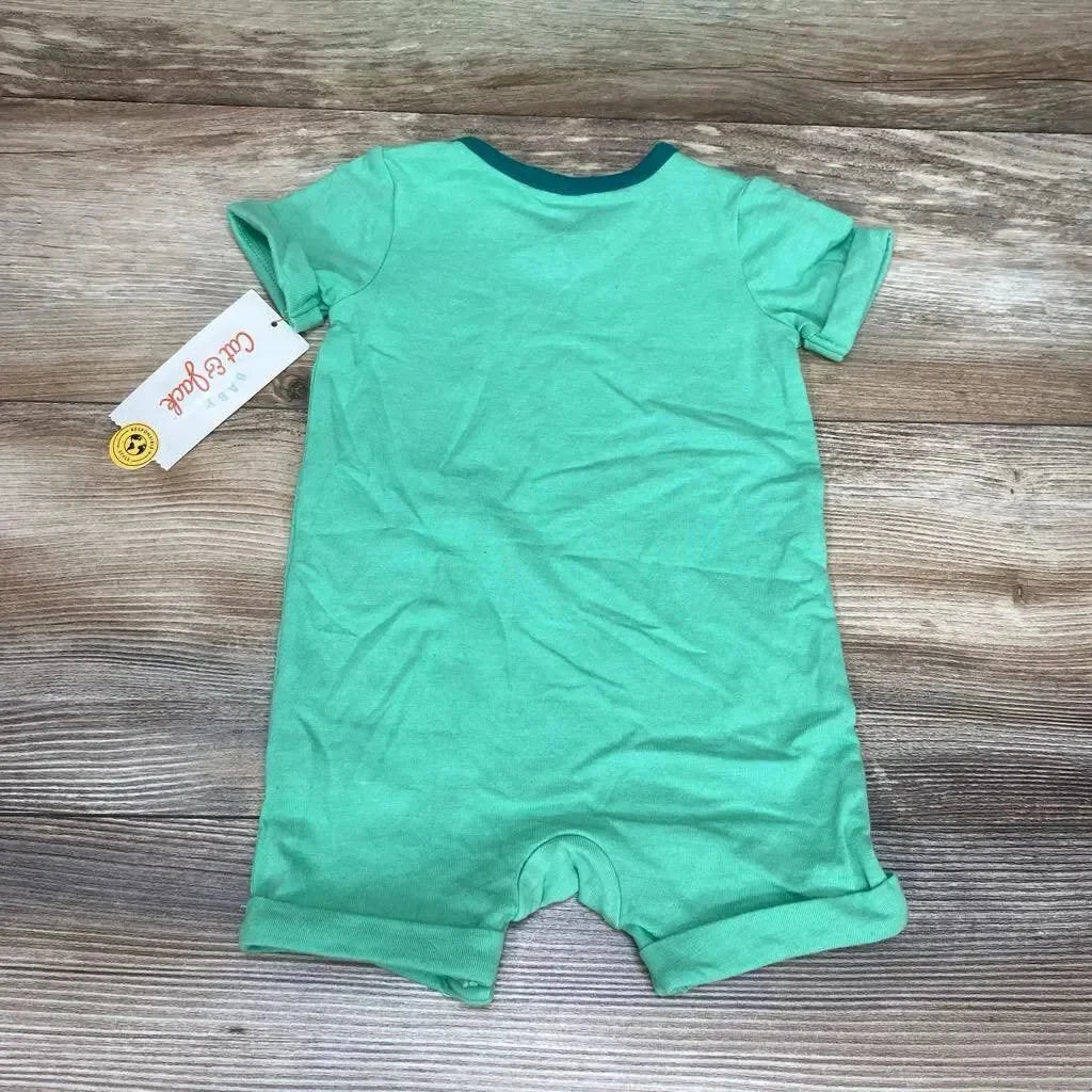 Flat-lay back view of Cat & Jack green short-sleeve romper (3-6 months) showing rolled leg cuffs and contrast teal neck trim on wood background