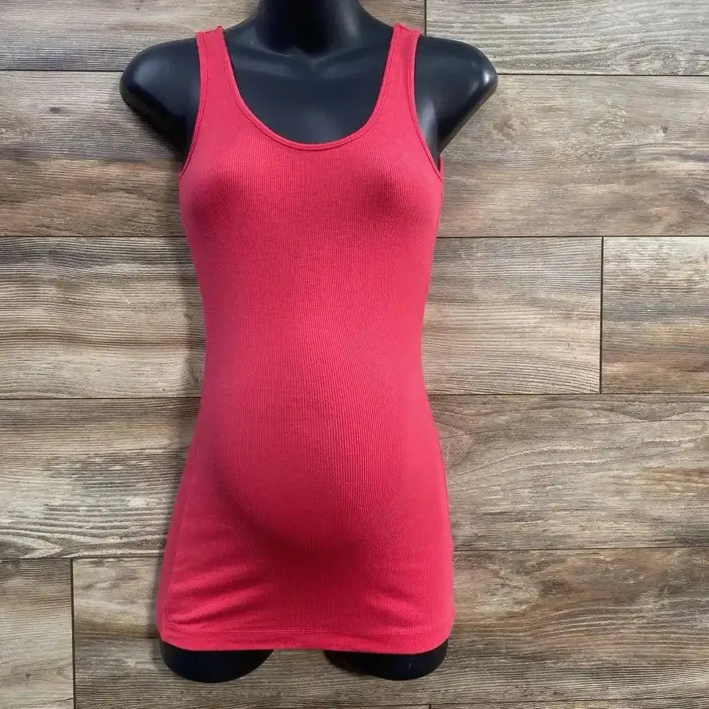 Front view of pink ribbed maternity tank top on a mannequin showing fitted stretch over belly with wood plank background