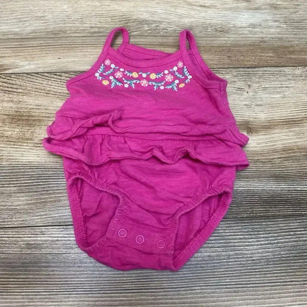 Front view of pink Carters newborn romper with embroidered floral neckline, ruffle tiers and snap crotch on wood background
