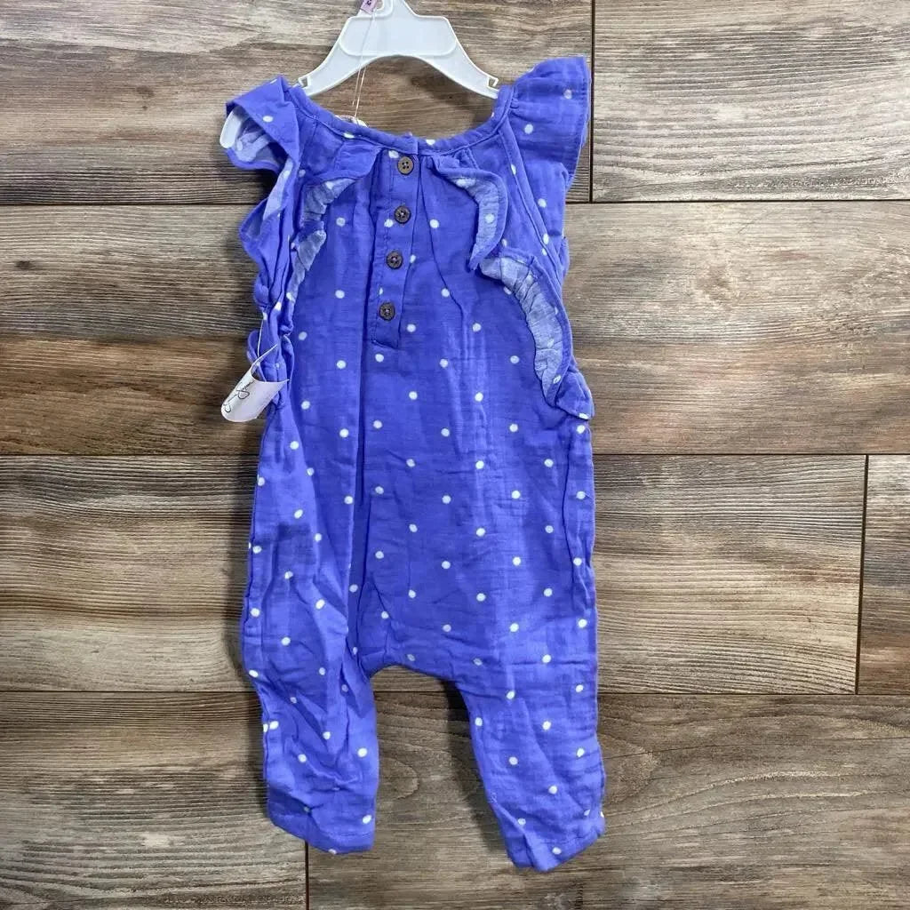 Front of purple Jessica Simpson baby romper (6-9m) with white polka dots, ruffle shoulders and wood floor background