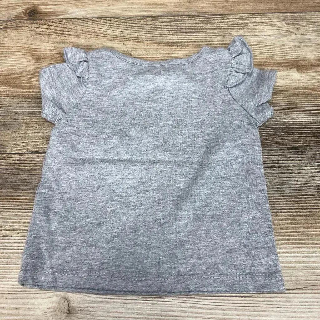 Back view of grey Okie Dokie baby T-shirt showcasing ruffle short sleeves on wood background