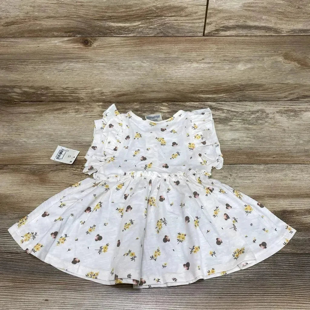 Flat lay of white Disney Junior Minnie floral henley dress (12m) showing ruffle sleeves and gathered waist on wood background