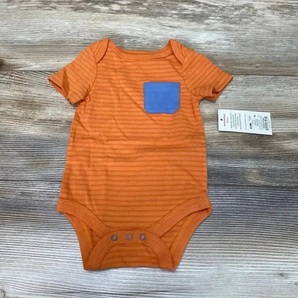 Flat lay of orange striped Cat and Jack bodysuit (0-3 months) showcasing a blue chest pocket and three snap closures on a wood background