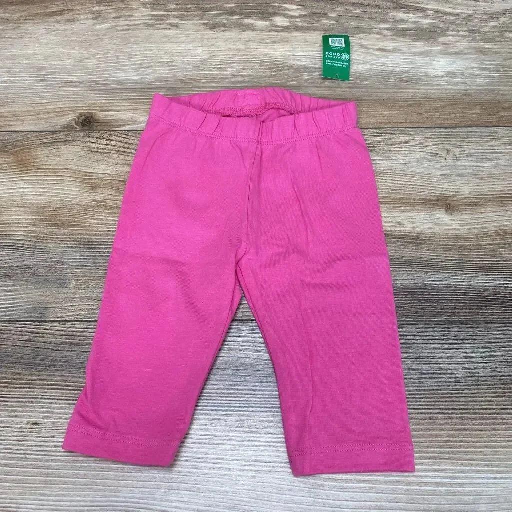 Flat lay of BabyGap solid pink leggings size 12 to 18 months showing elastic waistband and straight legs on wood background