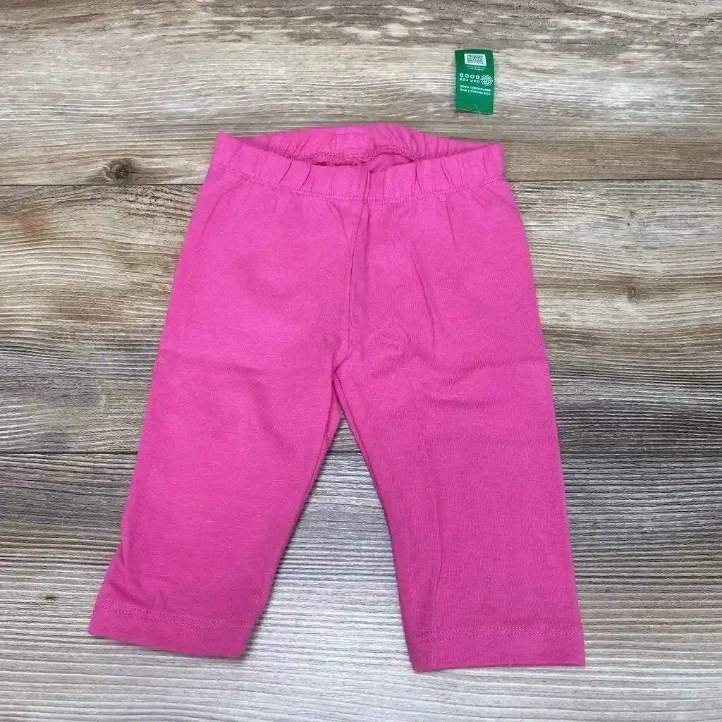Flat lay of BabyGap solid pink leggings size 12 to 18 months showing elastic waistband and straight legs on wood background