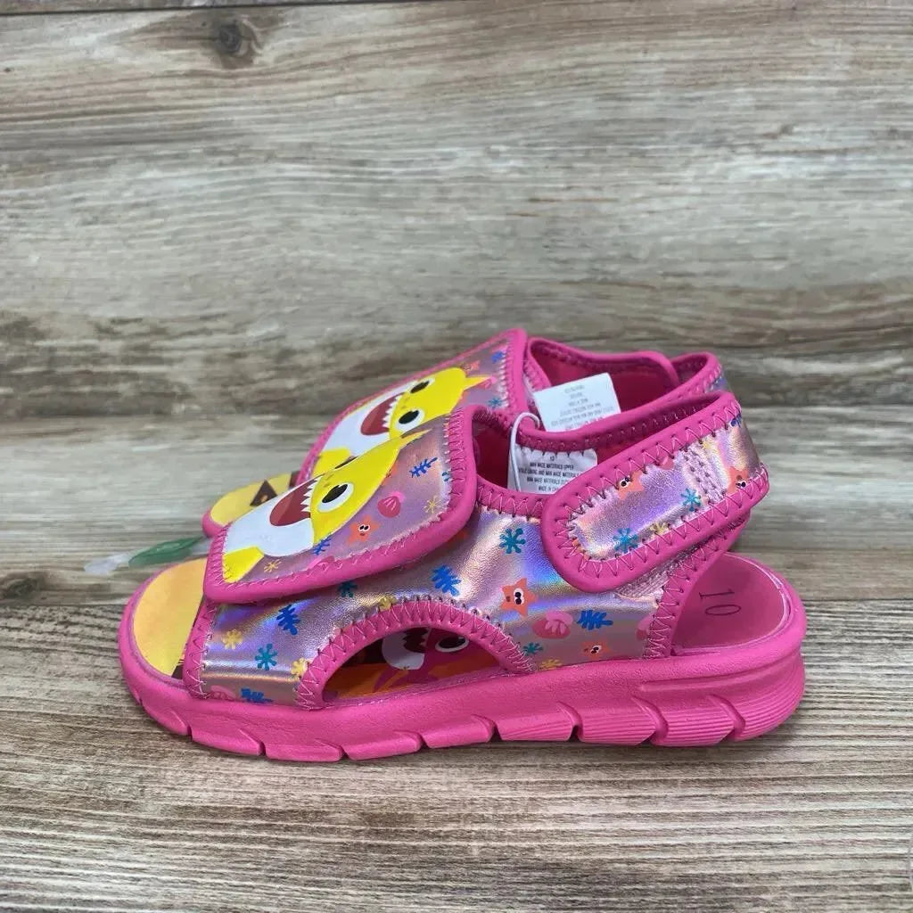 Side view of pink Baby Shark water sandal size 10c with velcro strap and cushioned sole on wood background