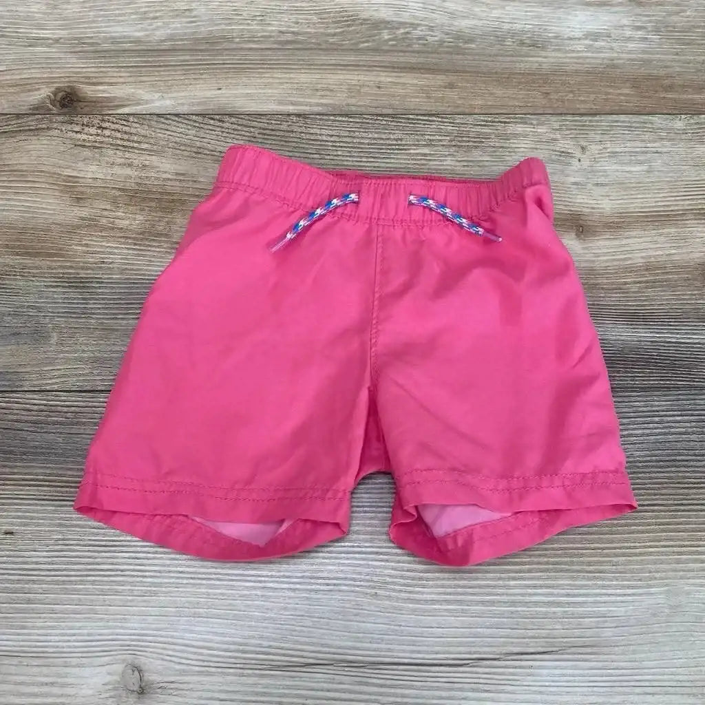Front view of pink Old Navy toddler swim shorts (12-18m) showing elastic waistband and braided drawstring on wood floor