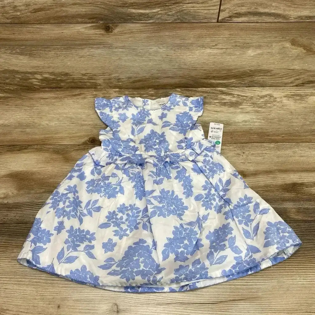 Front view of baby white dress with blue floral print and matching bloomers showing flutter sleeves and gathered waist on wood floor