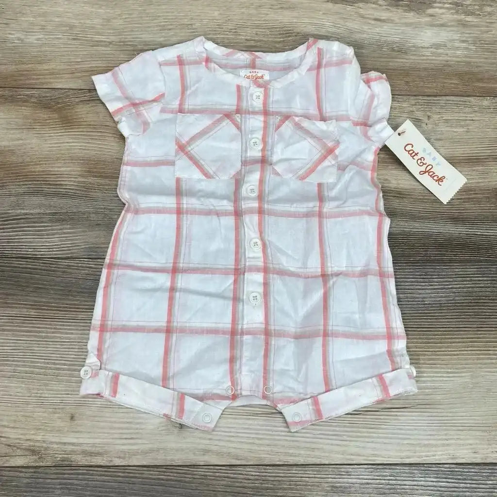 Front flat-lay of Cat & Jack shortie romper showing white fabric with pink plaid, front buttons and snap crotch on wood background