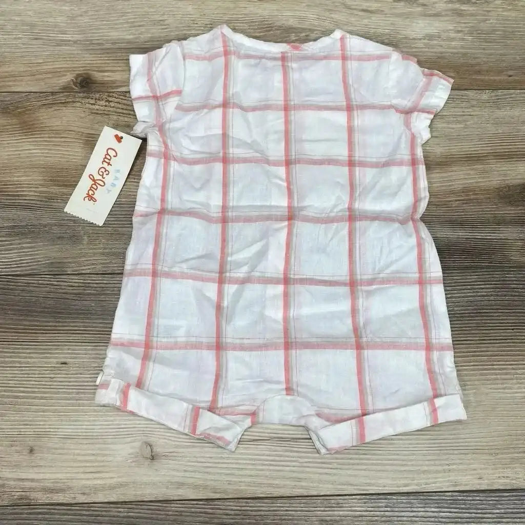 Flat lay of Cat and Jack shortie romper, white with pink plaid, size 3-6 months, short sleeves and snap crotch on wood background