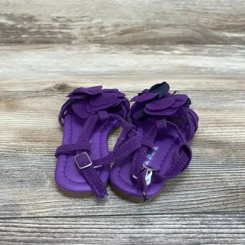 Top-down view of purple toddler strappy sandals (size 5C) showcasing layered flower embellishments and ankle buckles on a wood surface