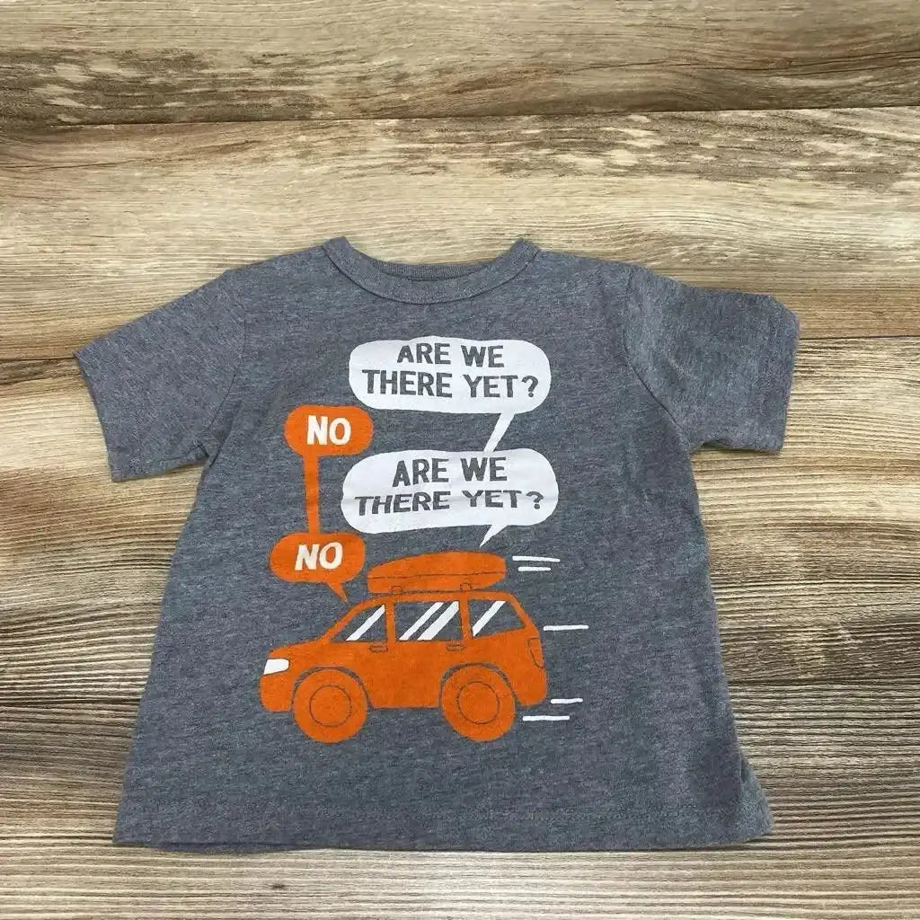 Flat lay of grey Children's Place toddler t-shirt (12–18m) showcasing orange car graphic and speech bubbles reading Are we there yet and No on wood background