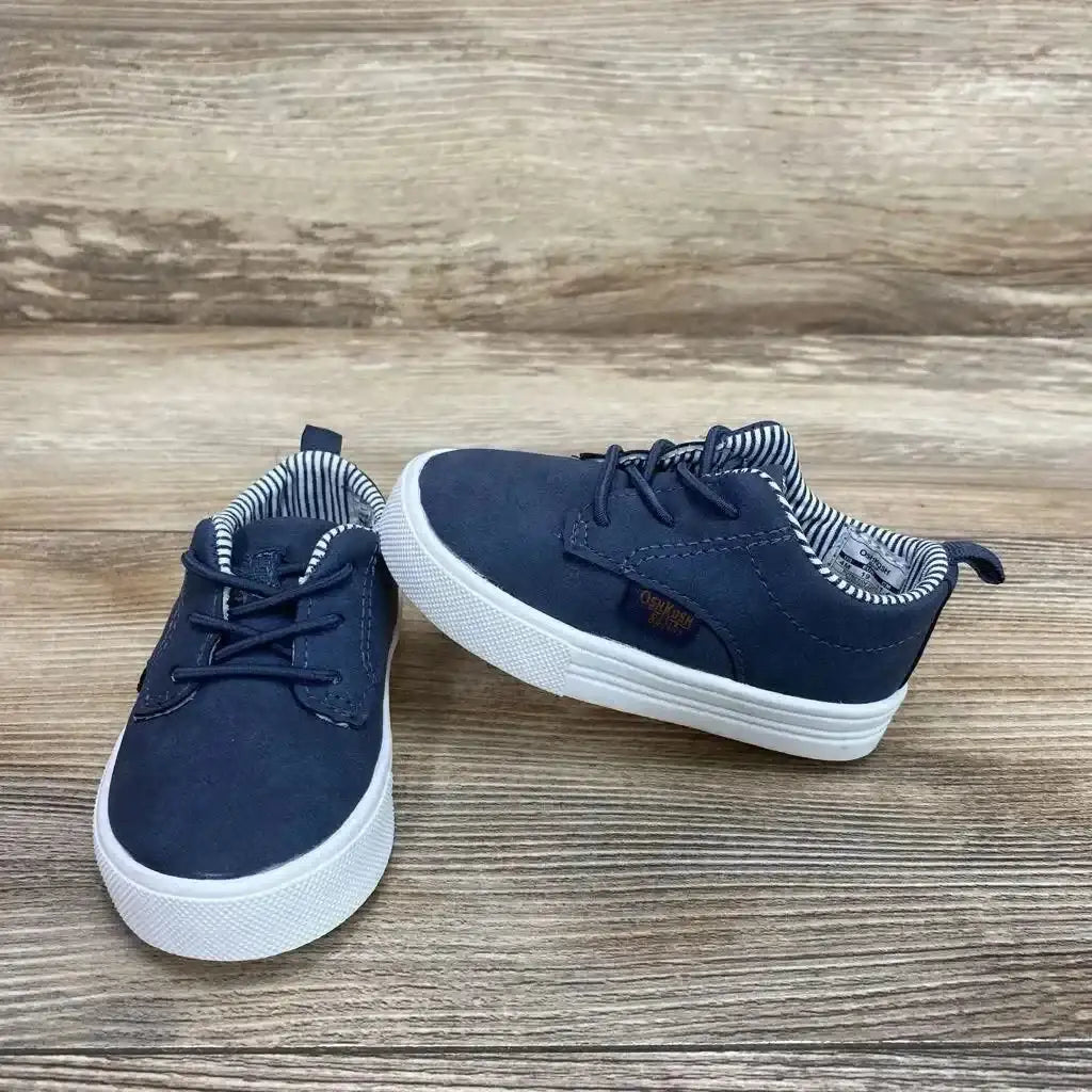 Angled view of OshKosh Putney Oxford casual sneakers Sz 4c showcasing faux laces and white soles on a wood surface