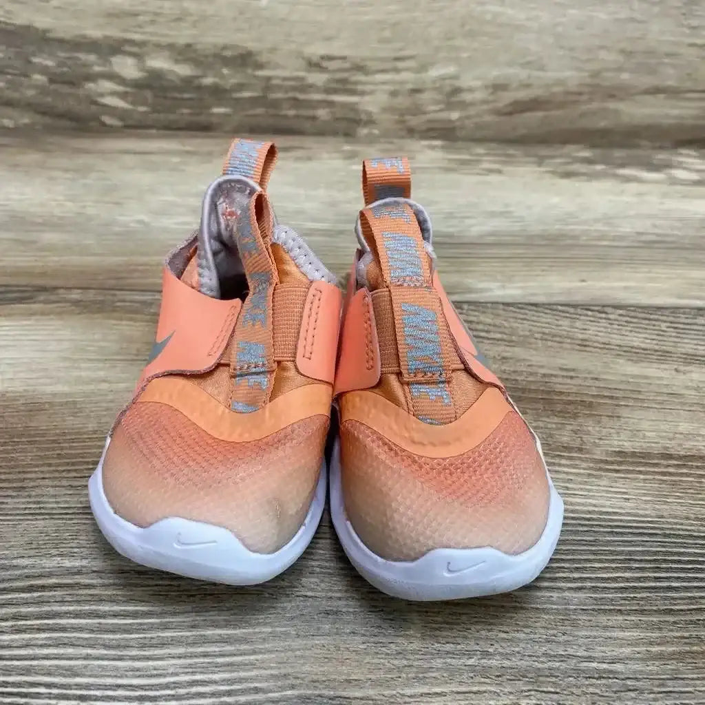 Front view of orange Nike Flex Runner sneakers size 5C with slip-on elastic strap and pull tabs on wood floor