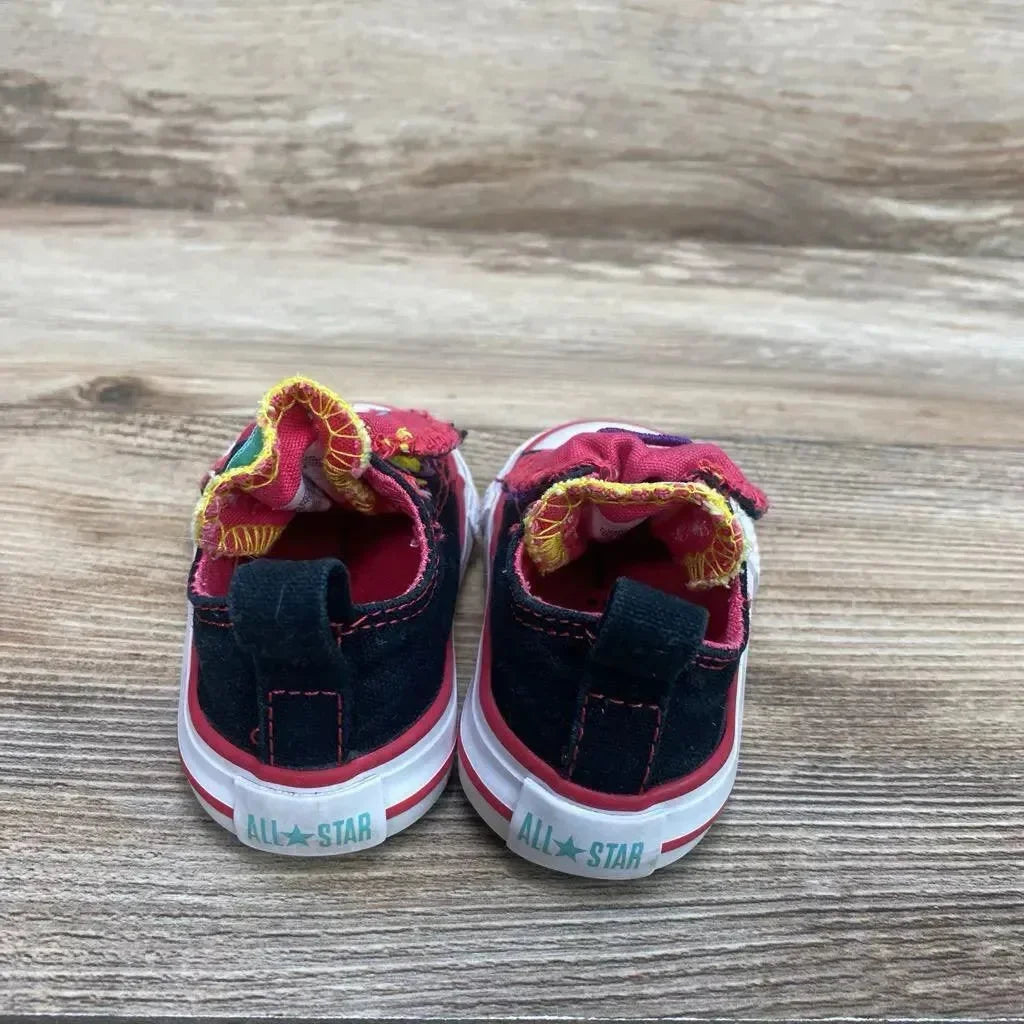 Rear view of toddler black Converse Chuck Taylor low-top sneakers 3C showing folded colorful tongues and All-Star heel on wood
