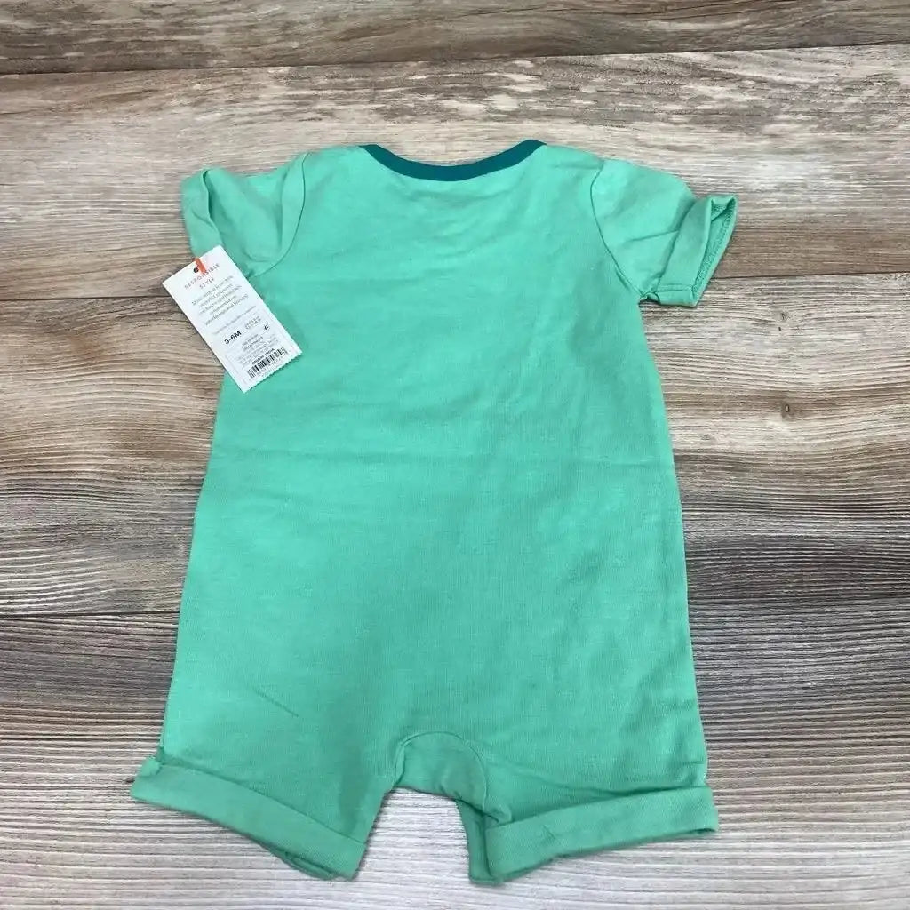 Back view of green Cat & Jack short-sleeve romper (3-6 months) showing folded cuffs and teal neckline on wood background