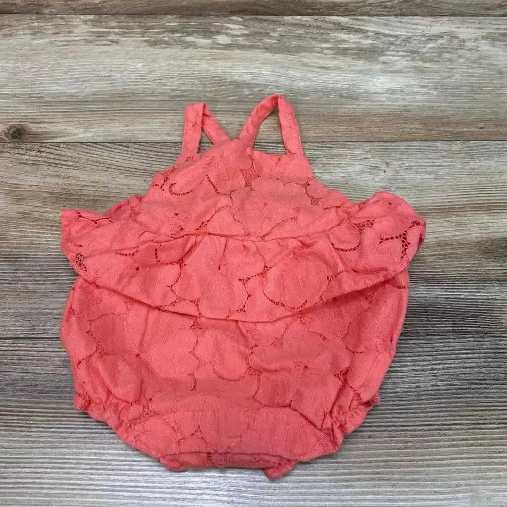 Flat lay of Janie and Jack lace peplum romper in coral pink showcasing floral eyelet lace and ruffle peplum with wood plank background