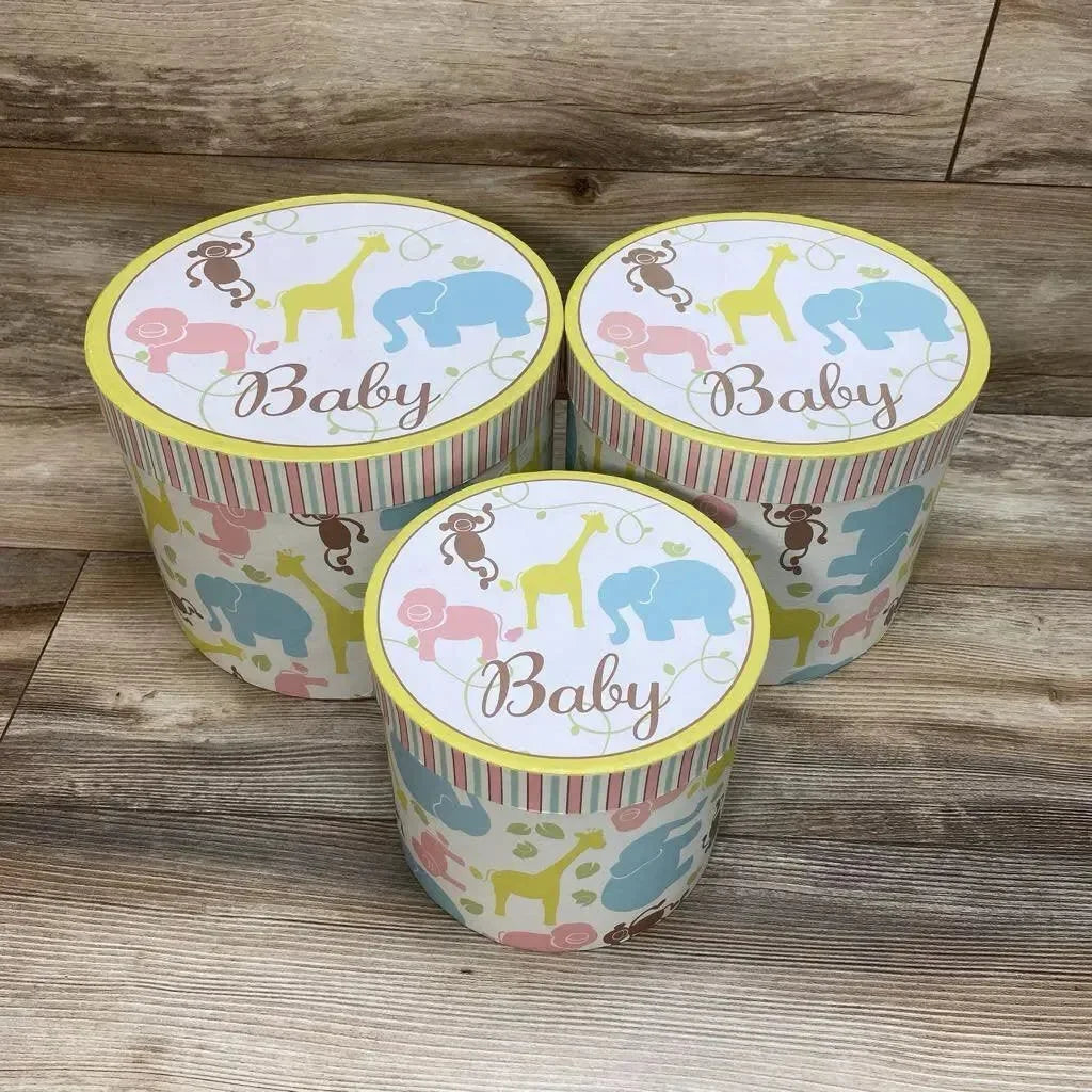 Front view of 3-piece Enchante Baby nesting trunks with pastel animal print and 'Baby' lids on wood floor