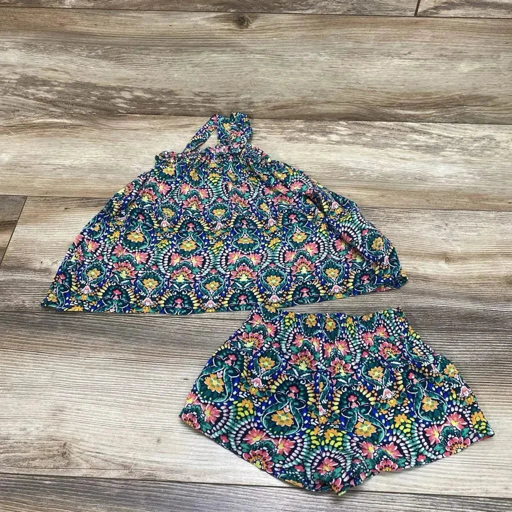 Flat lay of baby sleeveless halter top and matching shorts in green multicolor floral medallion print on wood floor