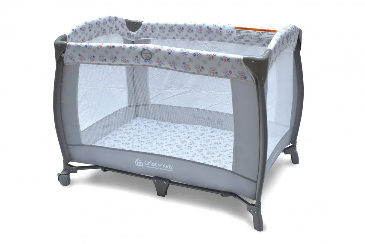 Gray portable baby crib playpen with mesh sides and patterned bedding on white background