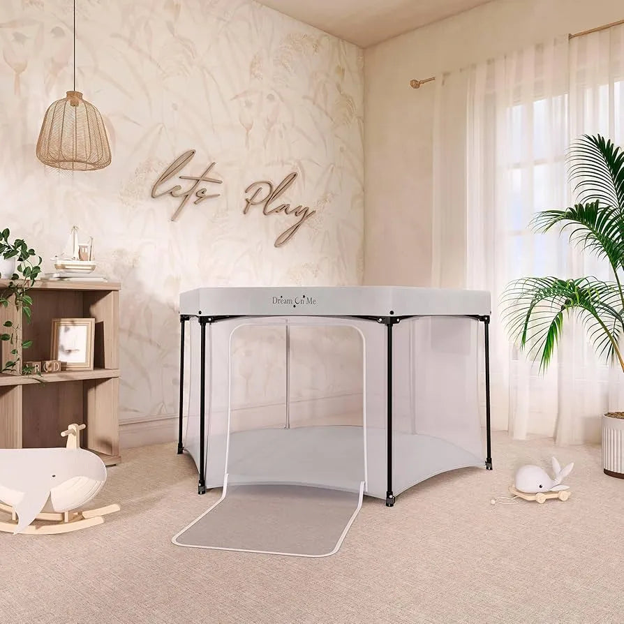 Modern nursery with Dream On Me playpen, natural decor, and wooden whale rocker