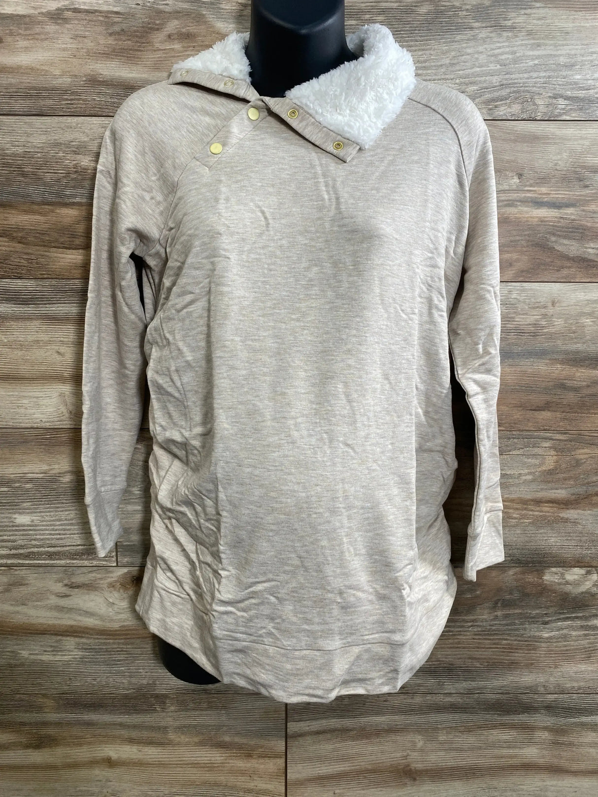 Front view of oatmeal maternity sweatshirt with sherpa snap collar and long sleeves on mannequin against wood background