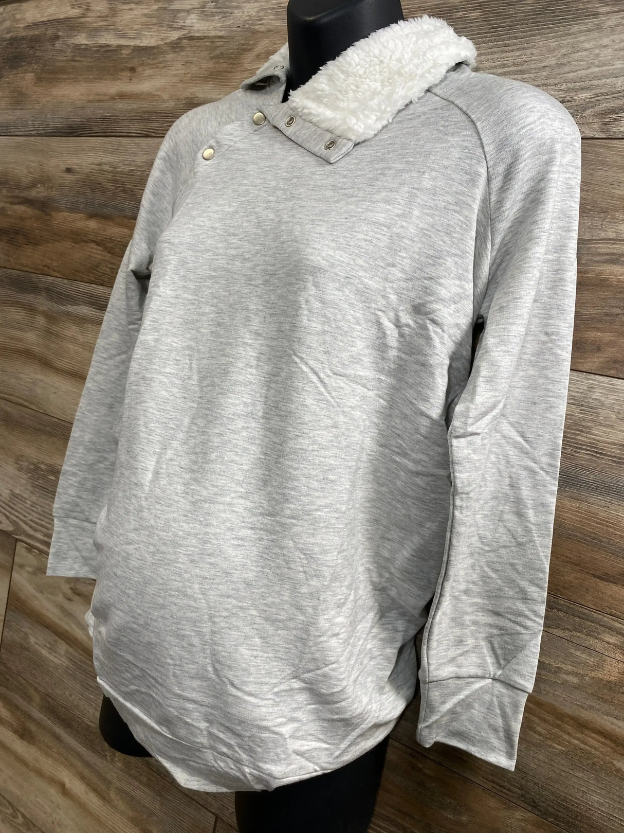 Front view of grey Isabel maternity sweatshirt, sherpa snap collar, long sleeves on mannequin with wooden backdrop